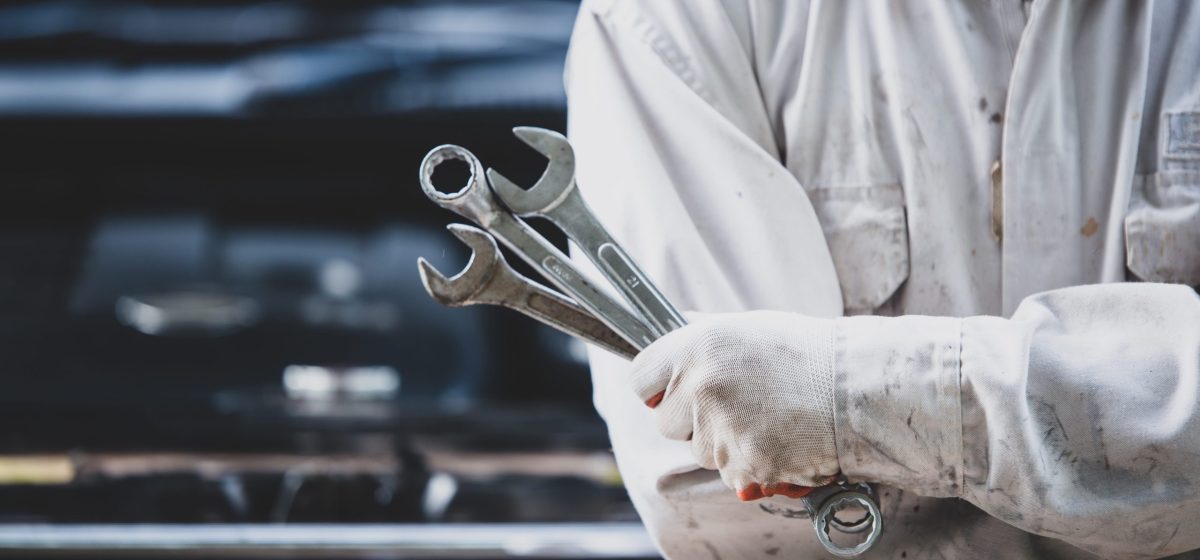 car repairman wearing white uniform standing holding wrench that is essential tool mechanic (1)